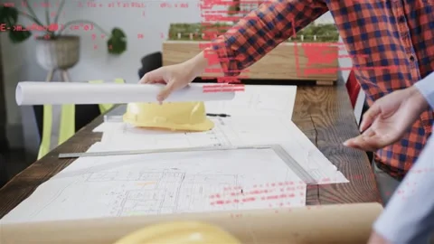 Team reaching for rolled plan, unrolling plans while red code overlay tracking Stock Footage 333300793