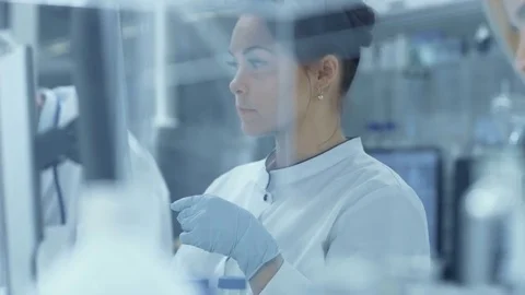 Team of Research Scientists Working With Microscope Stock Footage