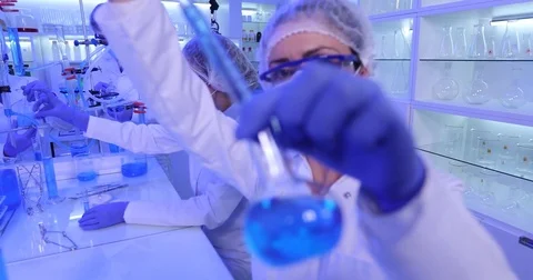 Team of Researchers Working Chemist Using Pipette to Transfer Liquid Laboratory Stock Footage 73555810