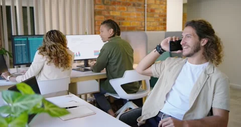 Team reviewing data at desk right male taking call, checking phone, typing on Stock Footage 337944496