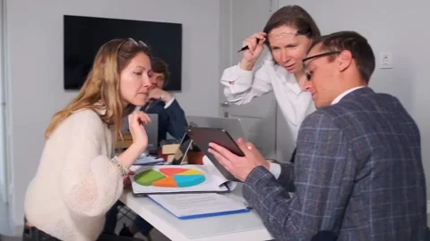 Team reviews chart, team collaboratively examines data segments to optimize Stock Footage 319565875