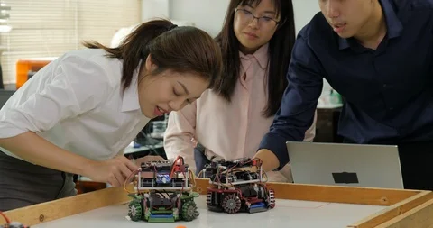 Team of robotics engineer assembling and testing robotics responses with laptop Stock Footage 94657077