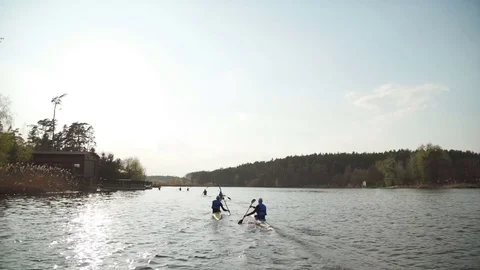 Team of rowing people sailing in sunset Stock Footage