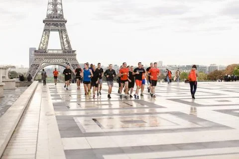 Team of runners running in Eiffel Tower background on Trocadero square, Paris. Stockfoto's