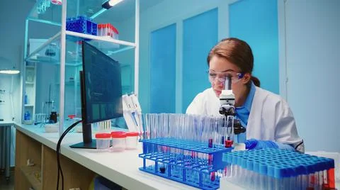 Team of scientist checking virus development using microscope Stock Photos