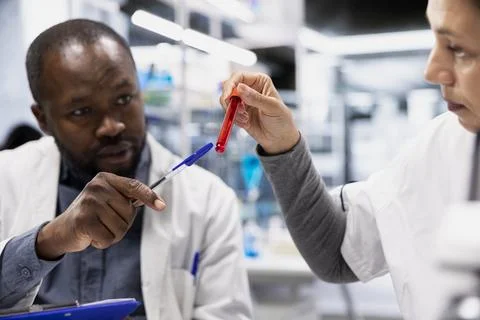 Team of scientists analyzing blood samples for hereditary disease markers 스톡 사진