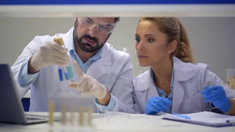 Team of scientists comparing chemical substances in laboratory Stock Footage 80358529