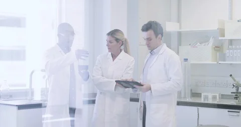 Team of scientists discussing experiment data on digital tablet Stock Footage 106947829