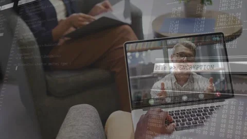 Team seeing remote call in lounge as laptop showing File ENCRYPTION overlay Stock Footage 333968358