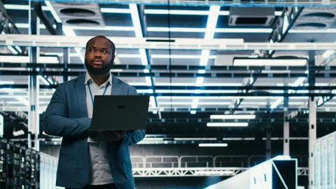 Team of server farm software developers using laptop to optimize electronics Stock Footage 330090166