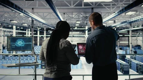 Team of server room technicians alerted by warning message on laptop Stock Footage 314683196