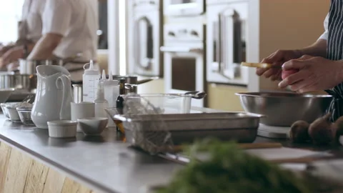 Team of skillfull chefs cutting and peeling food in pots and pans in interior ki Stock Footage 199462027