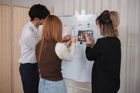 A team of software developers brainstormed to design a smartphone application by Stock Photos