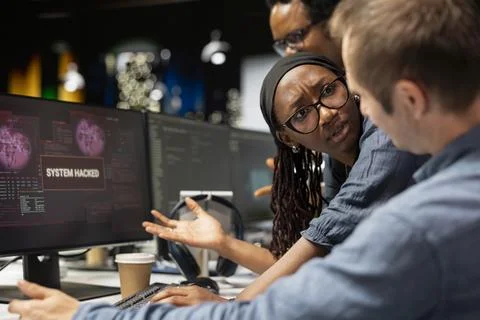 Team of software developers detecting and blocking hacker intrusion Foto stock