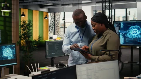Team of software developers in office automating workflows using AI Stock Footage 322708091