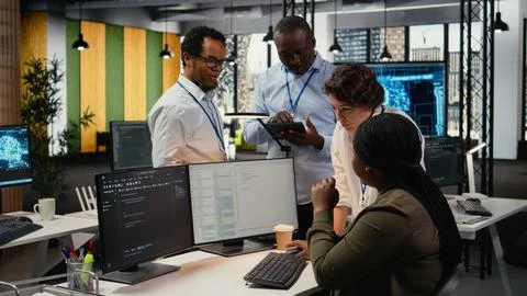 Team of software developers in office working together, automating using AI 스톡 사진