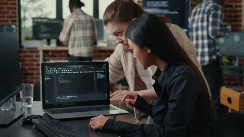 Team of software developers talking about source code running on laptop screen Stock Footage 168246041