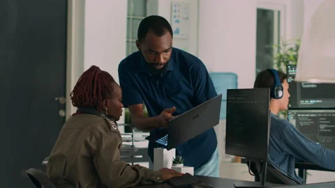 Team of software developers talking about source code running on laptop Stock Footage 220379992