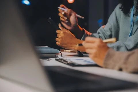 Team of software developers working on big project late at night in neon li.. 库存照片