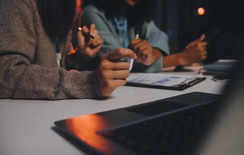 Team of software developers working on big project late at night in neon li.. 库存照片