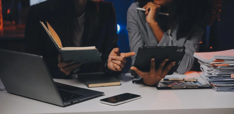 Team of software developers working on big project late at night in neon li.. 库存照片