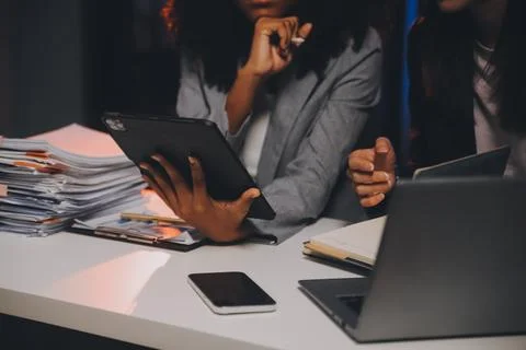 Team of software developers working on big project late at night in neon li.. 库存照片