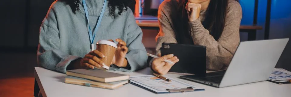 Team of software developers working on big project late at night in neon li.. 库存照片