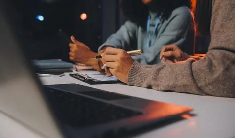 Team of software developers working on big project late at night in neon li.. 库存照片