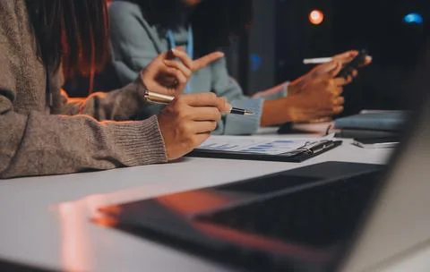 Team of software developers working on big project late at night in neon li.. 库存照片