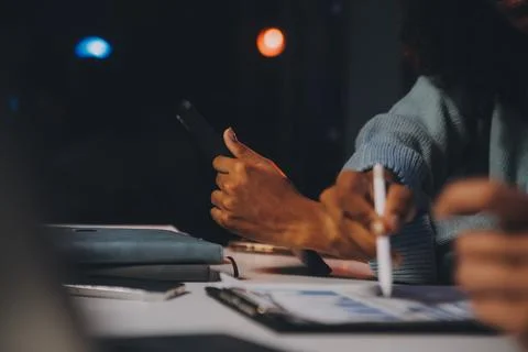 Team of software developers working on big project late at night in neon li.. 库存照片