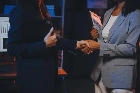 Team of software developers working on big project late at night in neon li.. 库存照片