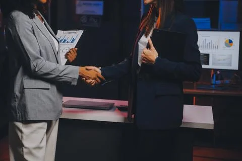 Team of software developers working on big project late at night in neon li.. 库存照片