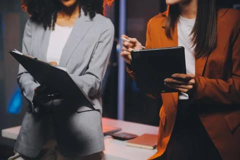 Team of software developers working on big project late at night in neon li.. 库存照片