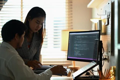 Team of software developers working with coded data on computer screen at dark Stockfoto's