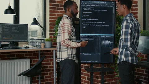 Team of software engineers leaving after analyzing source code on wall screen tv Stock Footage 168252659