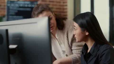 Team of software engineers talking about source code running on laptop screen Stock Footage 168231946