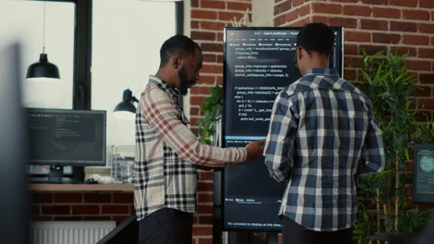 Team of software programmers leaving after analyzing source code on wall screen Stock Footage 168244026