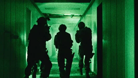 Team of soldiers with guns moving down a corridor night-vision Stock Footage 275094972