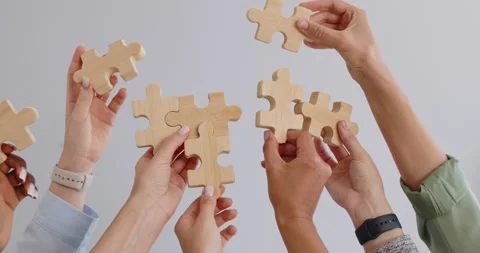 Team solving concept with hands lifting wooden puzzle pieces, strategy and unity Stock Footage 319722839