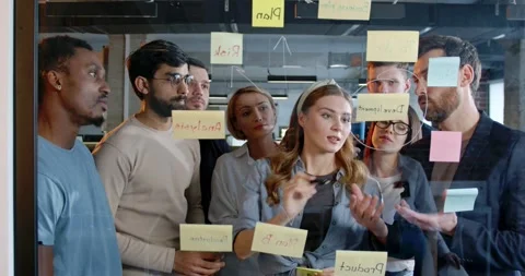 Team of startup project standing in front of board with tasks and to-do notes Stock Footage 180037470