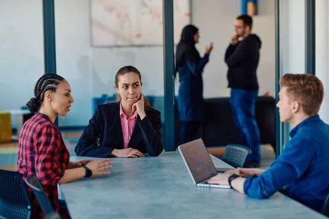 A team of successful programmers sits in a startup office, strategizing new Fotos Stock
