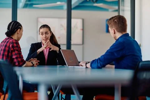 A team of successful programmers sits in a startup office, strategizing ne... Stock-Fotos