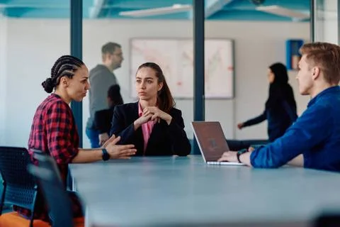 A team of successful programmers sits in a startup office, strategizing ne... Stock-Fotos