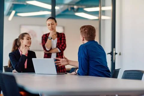 A team of successful programmers sits in a startup office, strategizing ne... Stock-Fotos