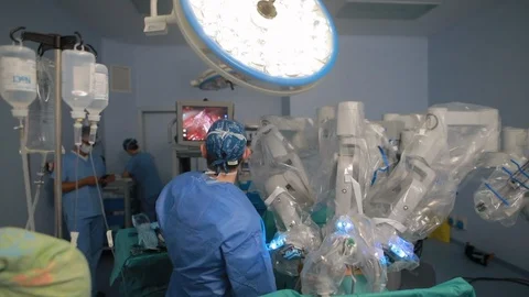Team of surgeons doctors in operations room using robotic arms for surgery ro 動画素材 102223828