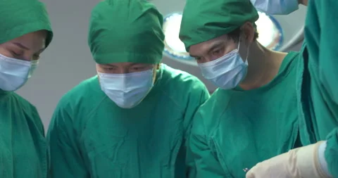 Team of surgeons in operating theater performing operation on a patient. Stock Footage 138876039