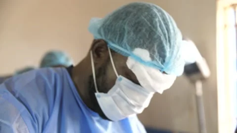 Team of surgeons in operating theater performing operation on a patient . Видео 154928613