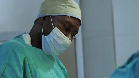 Team of surgeons in operating theater performing operation on a patient . Видео 156015783