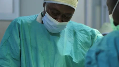 Team of surgeons in operating theater performing operation on a patient . Видео 156016552
