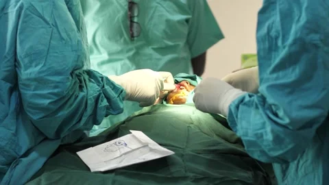 Team of surgeons in operating theater performing operation on a patient . 库存影片 156118643